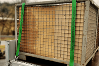Gitterbox auf einem Anh&auml;nger mit gr&uuml;nen Spanngurten umwickelt, auf denen das Firmenlogo gedruckt wurde
